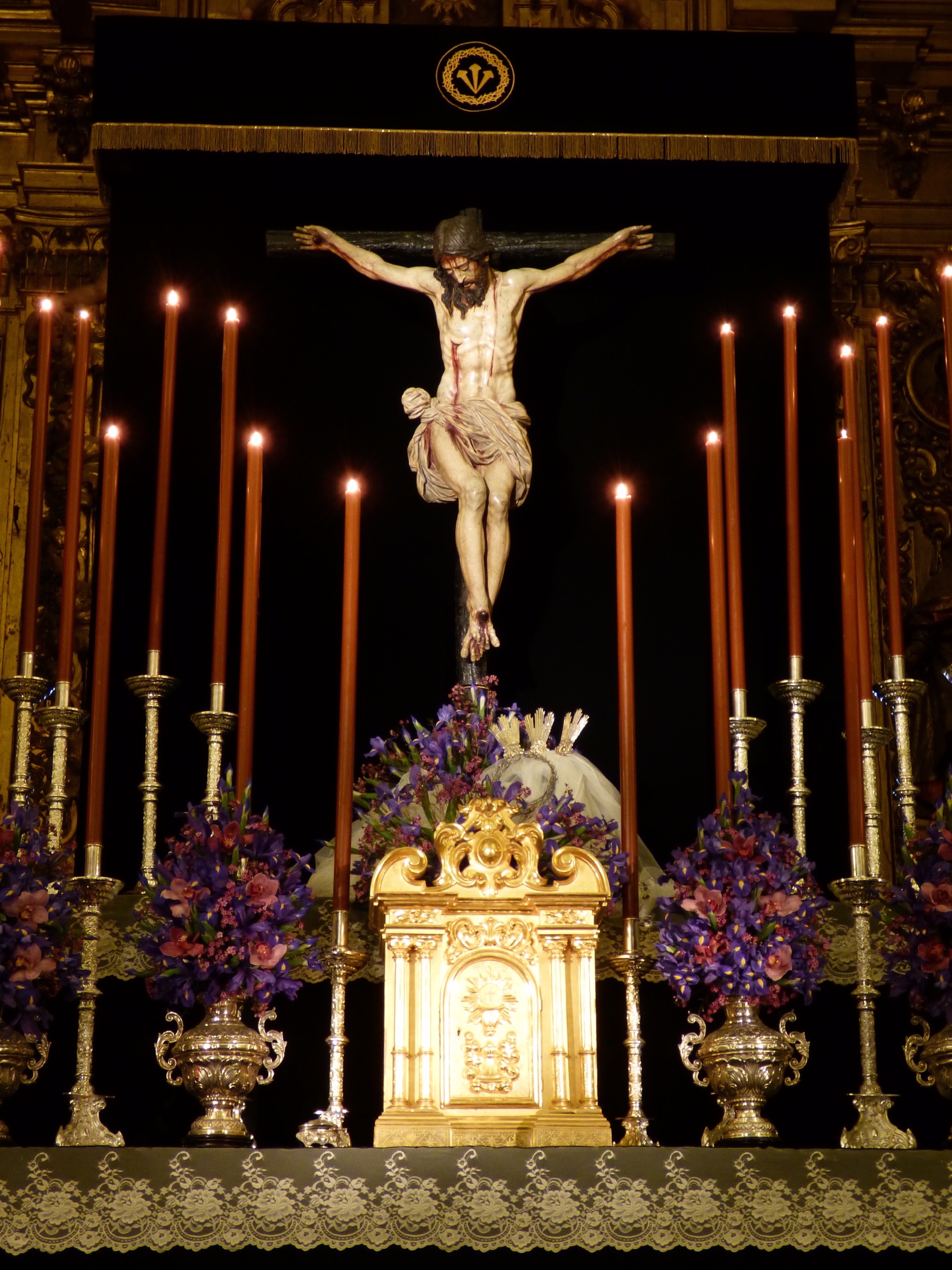 Santísimo Cristo de la Misericordia dispuesto para el culto con cirios y flores moradas